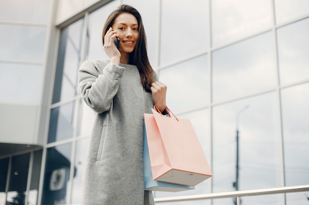 Ragazza carina con shopping bag in una città