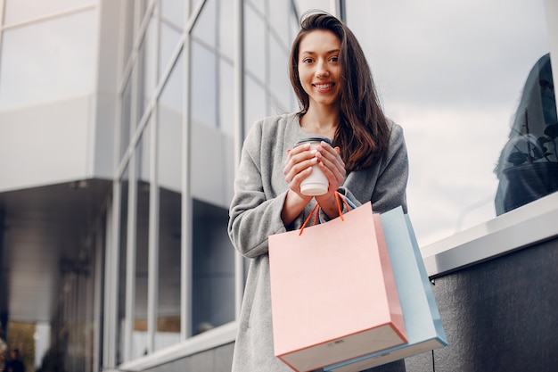 Ragazza carina con shopping bag in una città