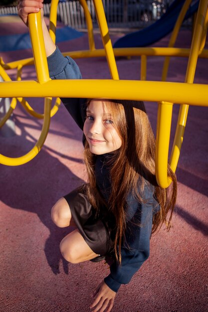 Ragazza carina divertendosi al parco giochi all'esterno