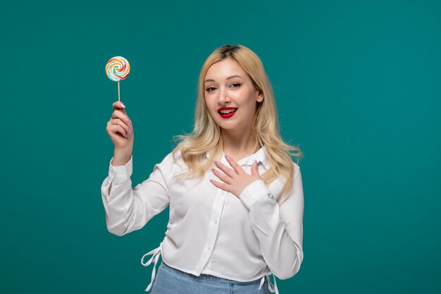 Ragazza carina giovane adorabile ragazza carina in una camicia bianca ordinata che tiene petto e un lecca-lecca