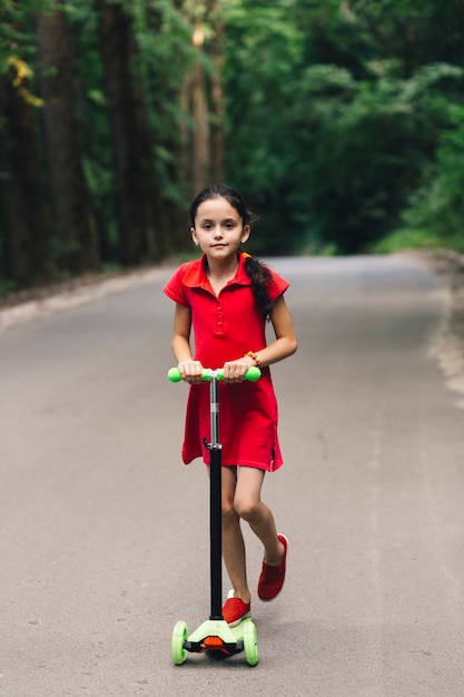 Ragazza carina godendo giro su scooter push