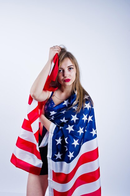 Ragazza carina in reggiseno e pantaloncini con bandiera americana degli Stati Uniti isolata su sfondo bianco