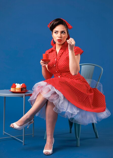 Ragazza carina pinup in posa con cupcakes