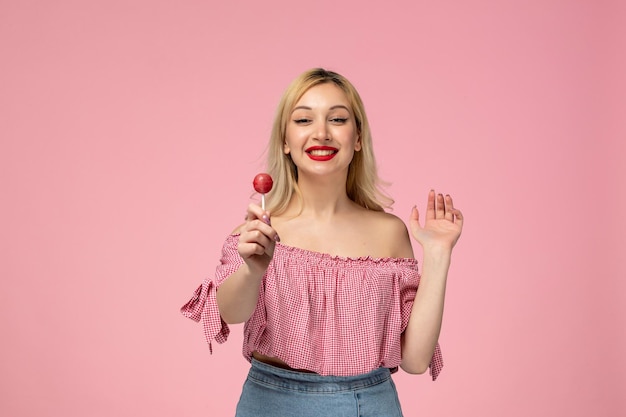 Ragazza carina ragazza adorabile con rossetto rosso in camicetta rosa regalando un lecca-lecca