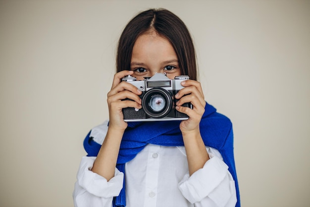 Ragazza carina tenendo la fotocamera e sorridente