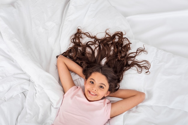 Ragazza carina vista dall'alto di cui a letto