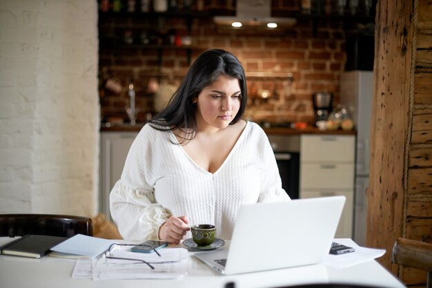 Ragazza castana latina che posa dell'interno