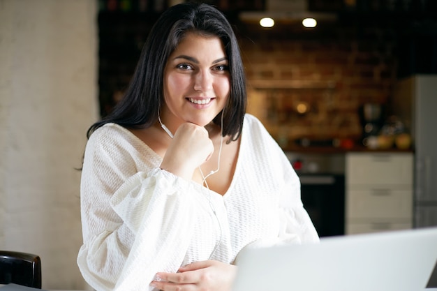 Ragazza castana latina che posa dell'interno