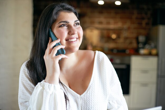 Ragazza castana latina che posa dell'interno