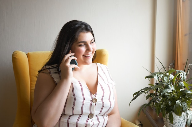 Ragazza castana latina che posa dell'interno