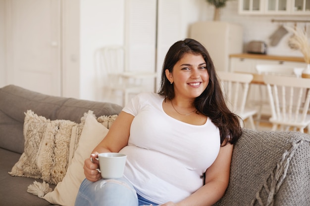 Ragazza castana latina che posa dell'interno