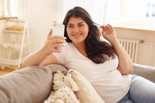 Ragazza castana latina che posa dell'interno