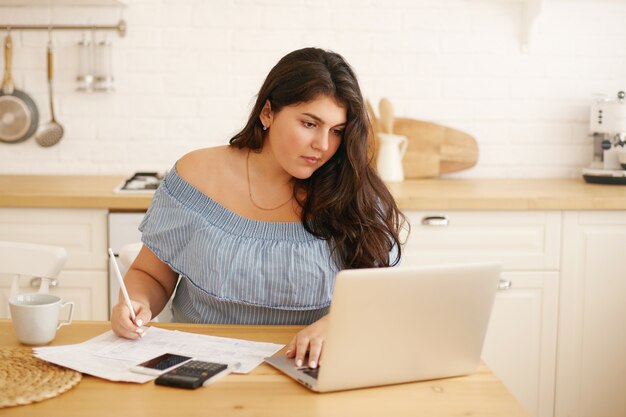 Ragazza castana latina che posa dell'interno