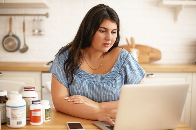 Ragazza castana latina che posa dell'interno