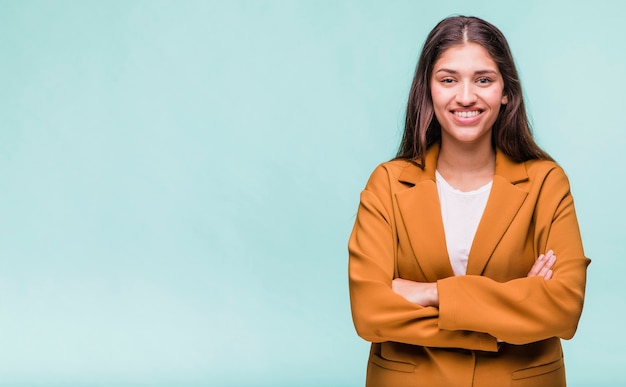 Ragazza castana sorridente che posa con il cappotto