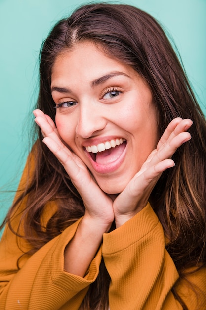 Ragazza castana sorridente che posa con il cappotto