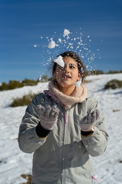 Ragazza caucasica che gioca con la neve in inverno