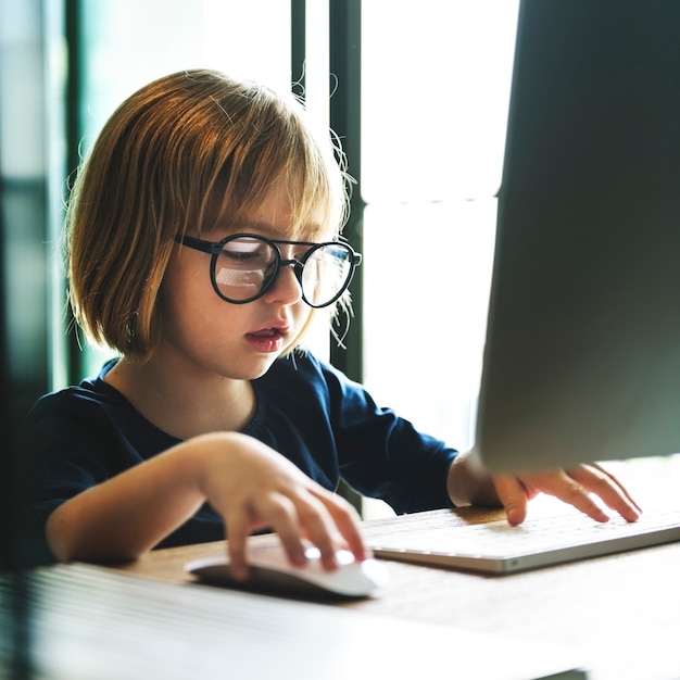 Ragazza caucasica che per mezzo del computer a casa