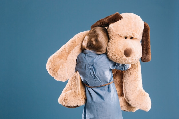 Ragazza che abbraccia il giocattolo della peluche