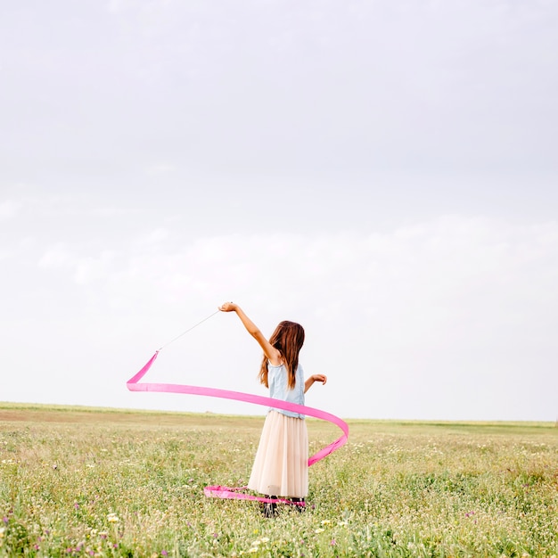 Ragazza che balla con nastro rosa ginnastica