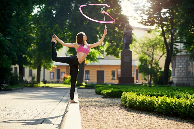 Ragazza che balla con un nastro nel parco cittadino.