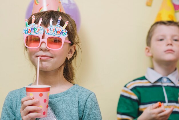 Ragazza che beve bevanda gustosa in festa