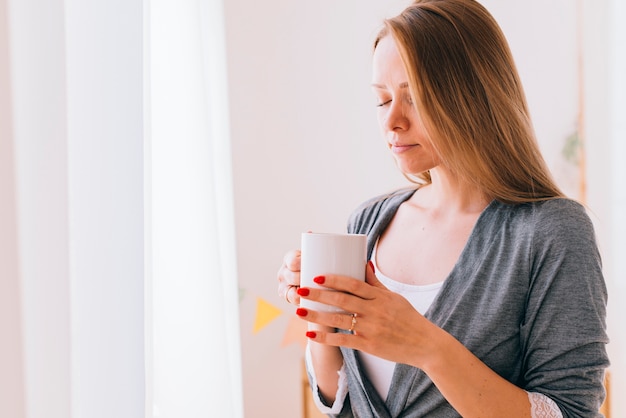 Ragazza che beve caffè al mattino