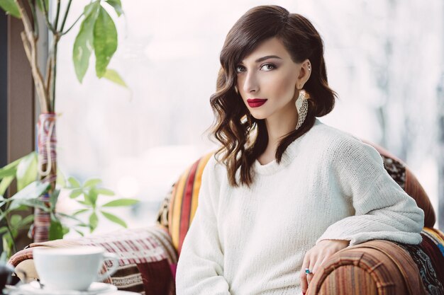 Ragazza che beve caffè in un caffè alla moda