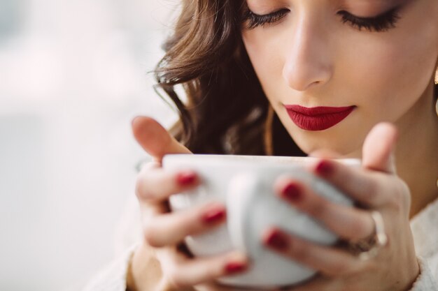 Ragazza che beve caffè in un caffè alla moda