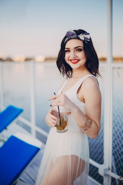 Ragazza che beve dal vetro mentre sorridendo