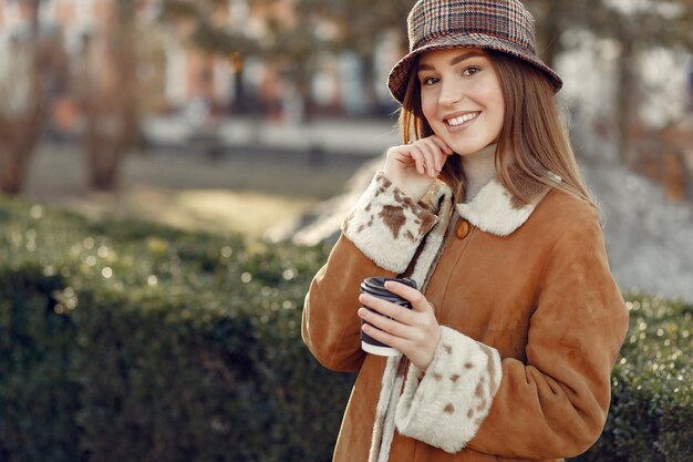 Ragazza che cammina in una città di primavera e prendendo caffè