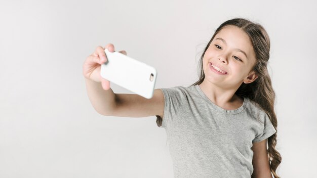 Ragazza che cattura selfie in studio