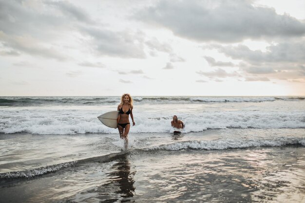 Ragazza che corre con la tavola da surf