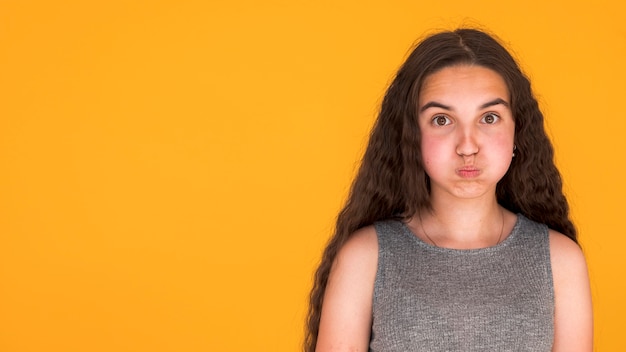 Ragazza che esamina sciocca la macchina fotografica con lo spazio della copia