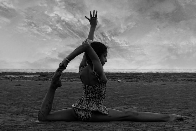 Ragazza che esegue i movimenti acrobatici in spiaggia