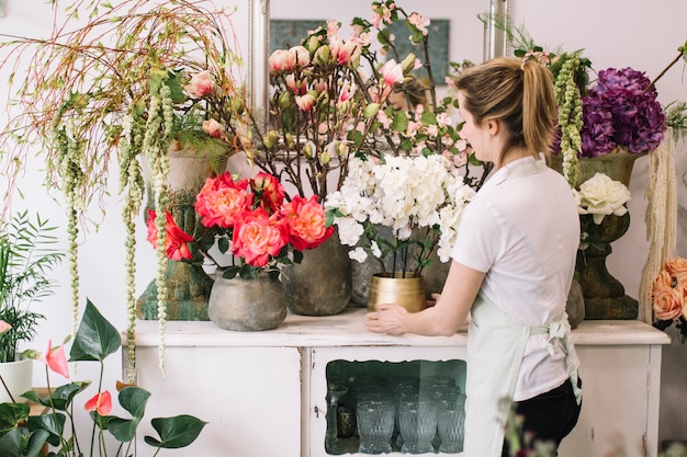 Ragazza che fa composizione floreale meravigliosa in negozio