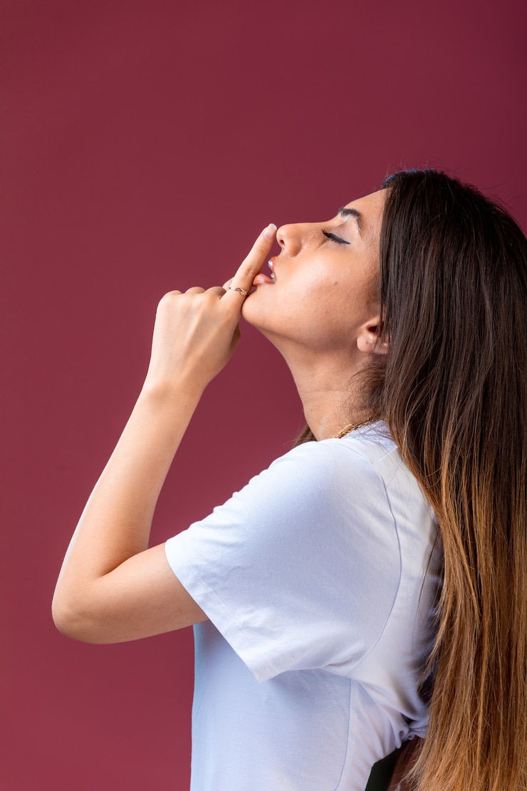 Foto gratuito ragazza che fa gest silenzioso in mano sul rosso.