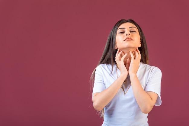 Ragazza che fa sognare o pregare gest in mano sul rosso.