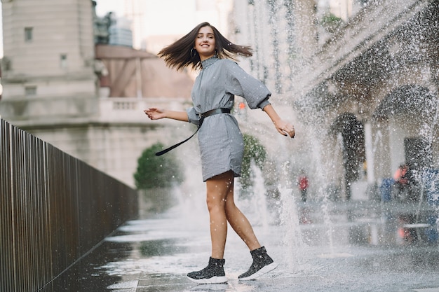 ragazza che gioca e balla in giro su una strada bagnata