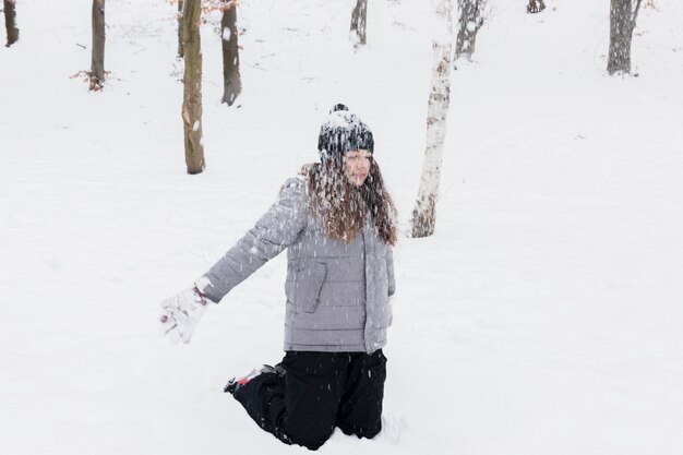 Ragazza che gioca neve nel parco