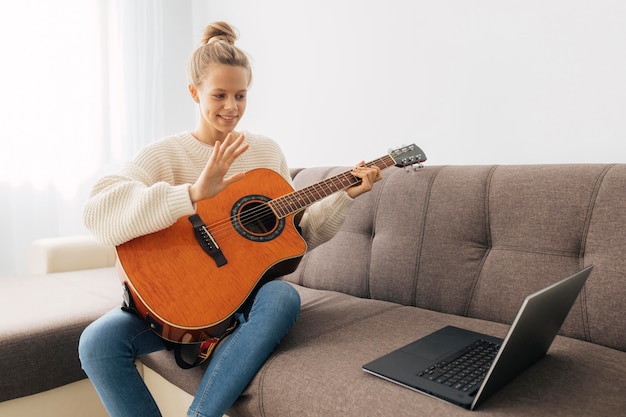 Ragazza che gioca una chitarra a casa