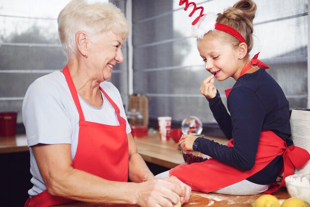 Ragazza che guarda sua nonna fare la pasta