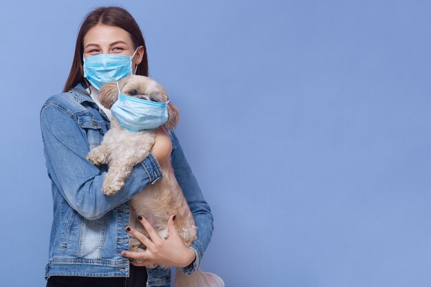 Ragazza che indossa maschera medica con il suo animale domestico