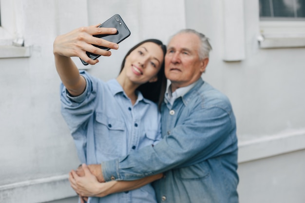 Ragazza che insegna a suo nonno come usare un telefono