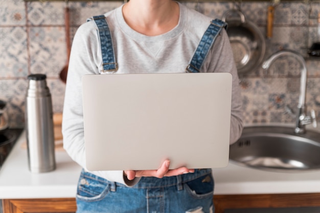 Ragazza che lavora al computer portatile grigio