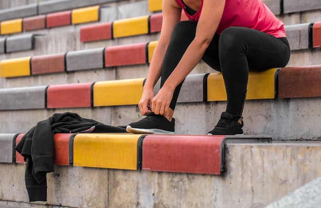 ragazza che lega i lacci delle scarpe da ginnastica