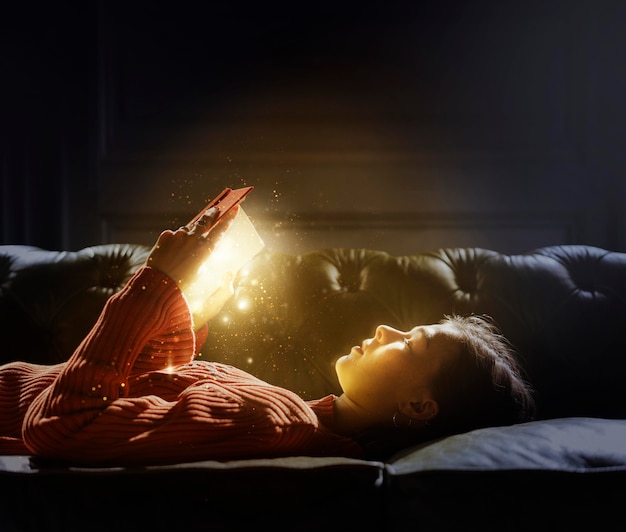 Ragazza che legge da un magico libro luminoso