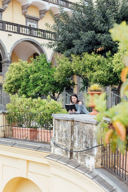 Ragazza che legge un libro in strada