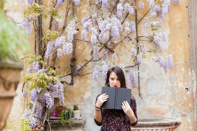 Ragazza che legge un libro in strada