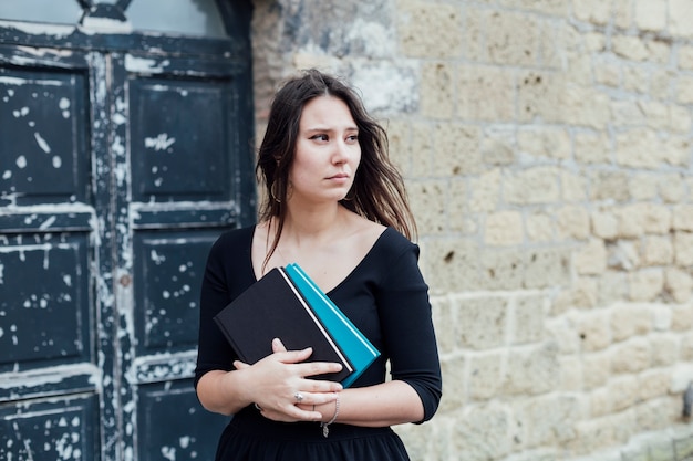 Ragazza che legge un libro in strada